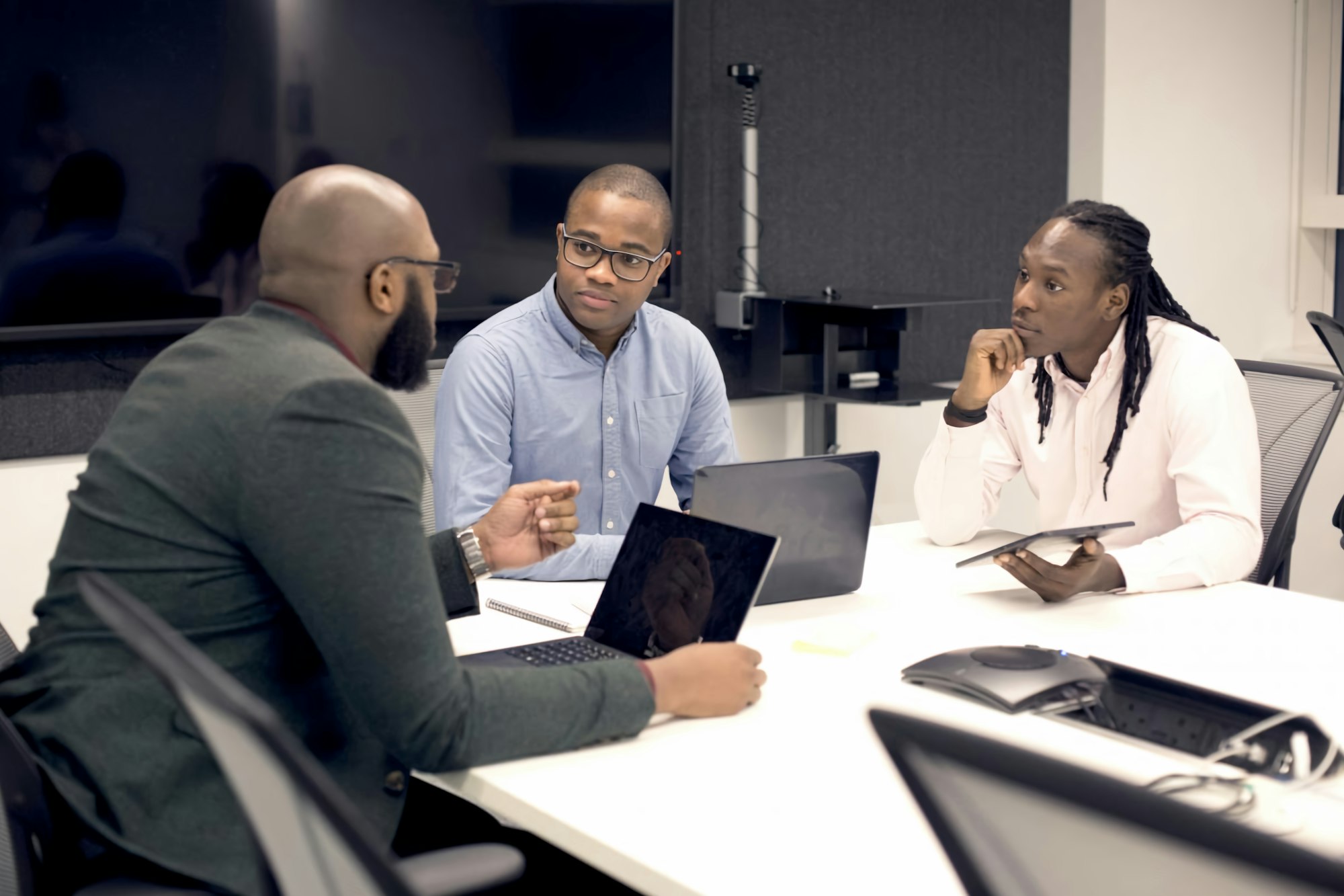 Business team meeting around laptops in a modern office